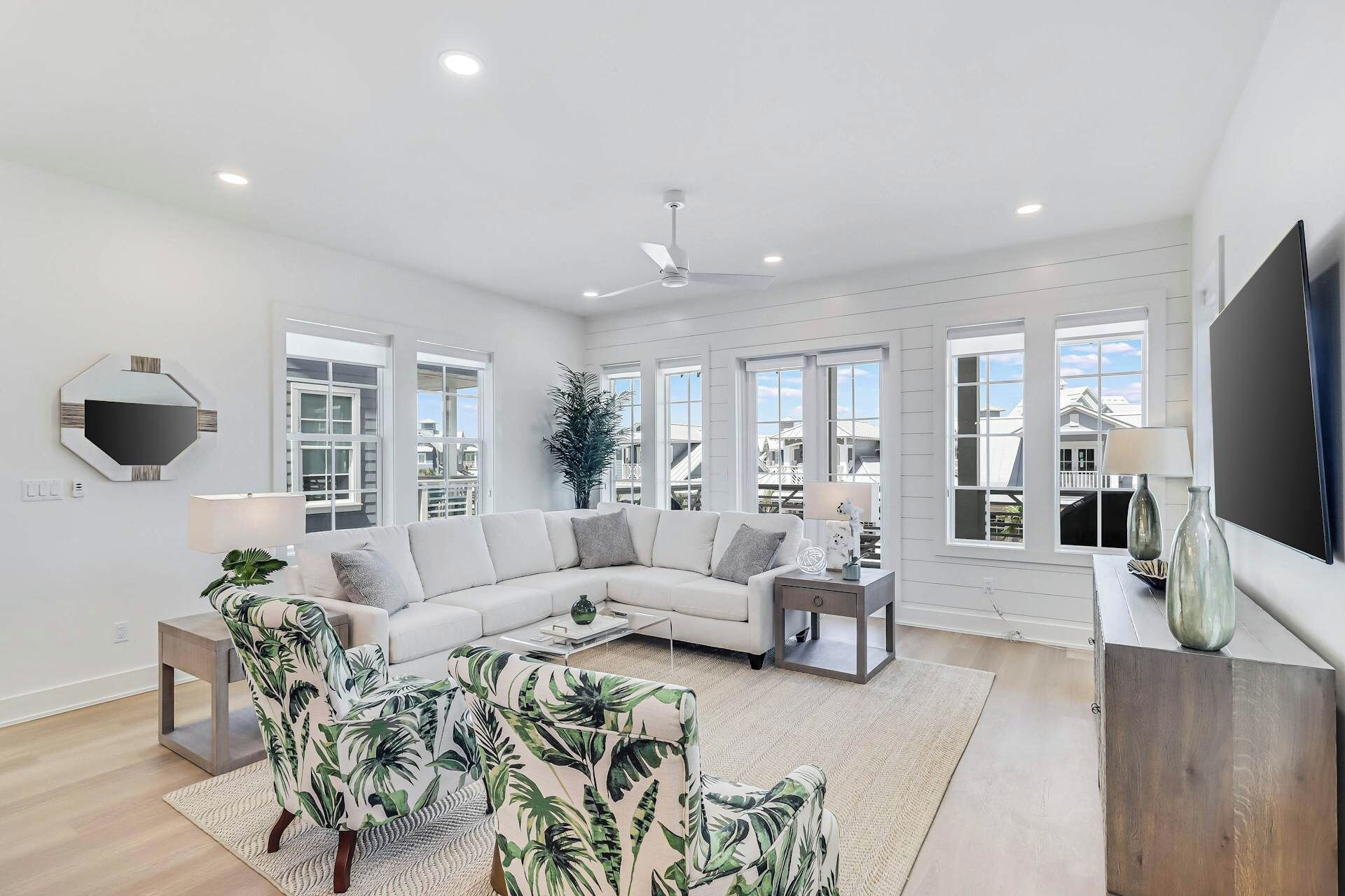 A spacious living room with a sectional sofa, a coffee table, a side table, and a television.