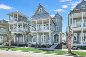 A beachfront property with multiple-story buildings, balconies, and a well-maintained lawn. - Sunrise Beach Bungalow | Steps to Beach and Resort (Port Aransas)