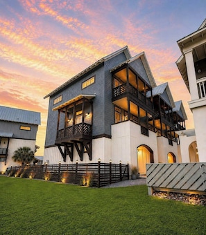 A multi-story building with balconies and large windows, surrounded by a well-maintained lawn. - Sunset On The 9th | Golf Views | Steps to Beach (Port Aransas)