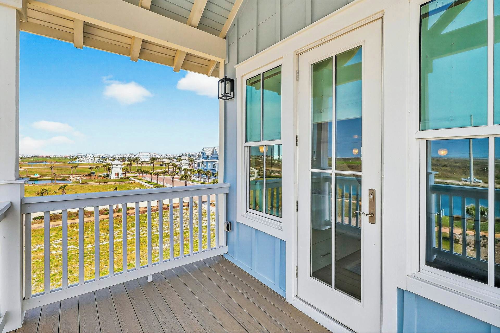 A covered porch with a view of a residential area.