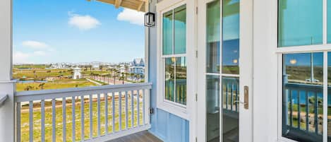 A covered porch with a view of a residential area.