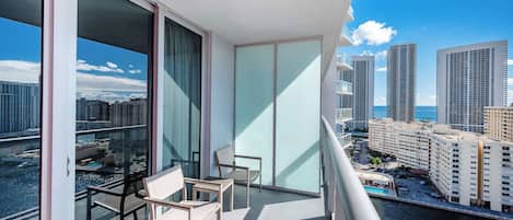 Un balcon donnant sur des immeubles imposants et sur une étendue d’eau.