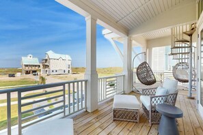 A covered porch with a view of a large house and beach. - The Coast Is Clear | Gulf Views | Private Pool (Port Aransas)