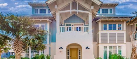 A two-story house with a prominent entrance, a balcony, and a garage.