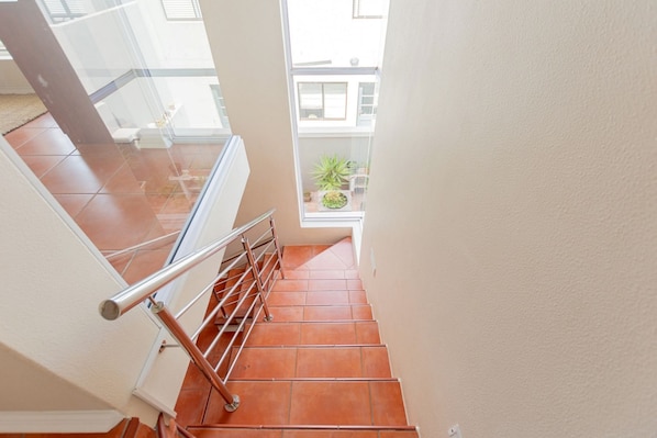 Eine Treppe mit Metallgeländern und Terrakottafliesen.