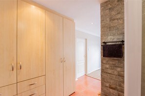 Ein Zimmer mit einem Holzkasten, einer Steinwand und einer Tür zu einem anderen Raum.