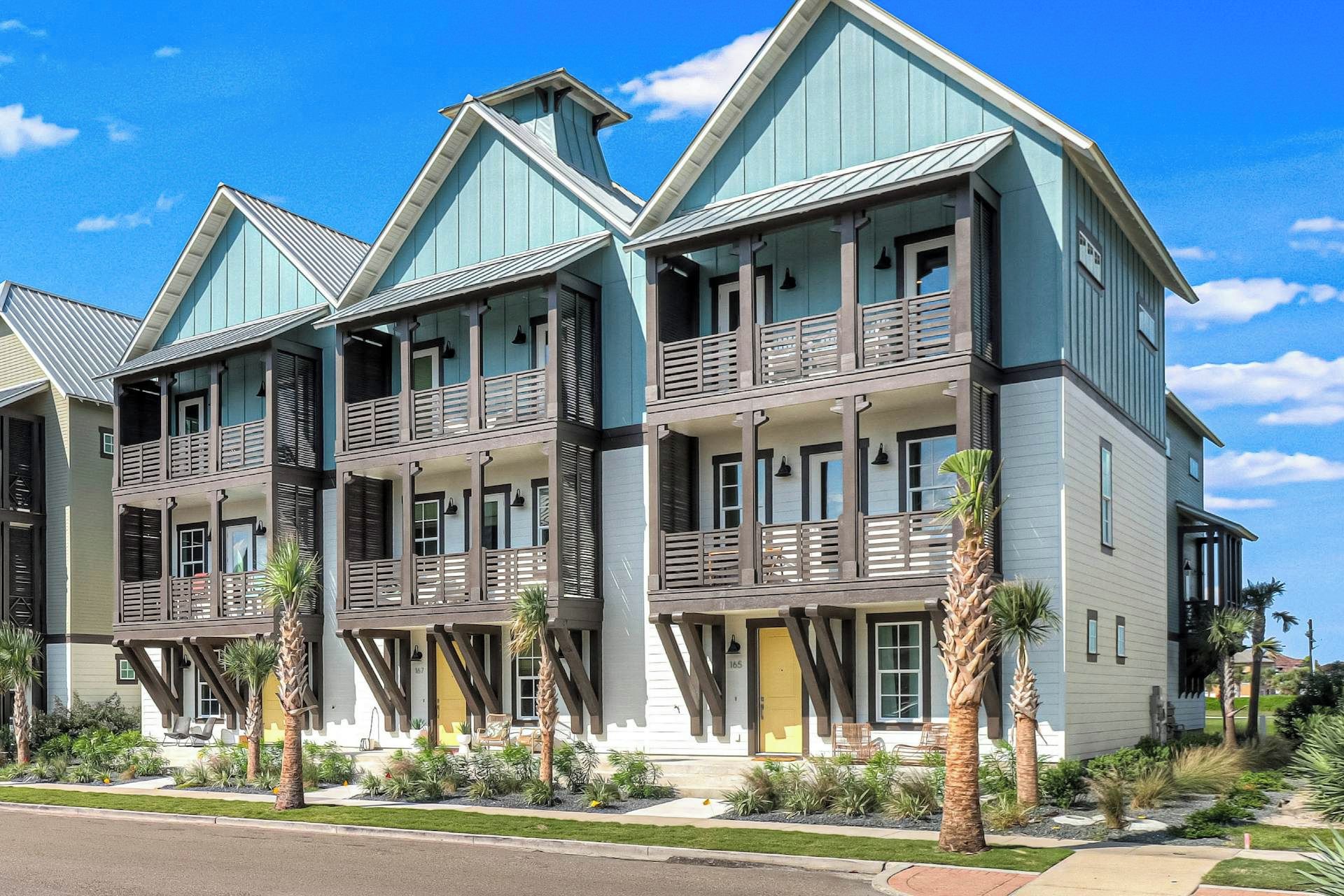 A multi-story building with balconies and a covered porch area.