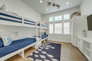 Ein Zimmer mit Etagenbetten, einem großen Fenster und einer Heizung.