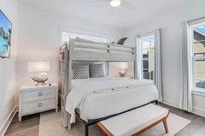 Een stapelbed met een bankje, bedlampjes en uitzicht op het omliggende landschap.