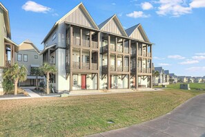 Een meerlaags woongebouw met balkons en een verzorgd gazon.