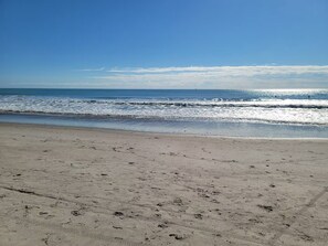 Una spiaggia con impronte sulla sabbia e un cielo sereno.