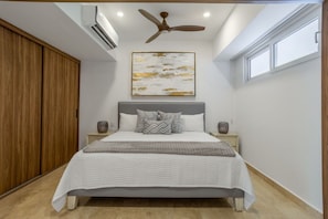A bedroom with a bed, nightstands, a ceiling fan, and a window. - Harbor 171 Beachfront  Walking Distance to the Malecón (Puerto Vallarta)