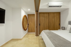 Ein Schlafzimmer mit einem Bett, einem Nachttisch, einer Klimaanlage und einem Holzschrank.