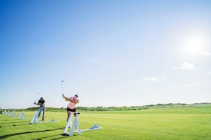En golfbana där spelare övar sina svingar.