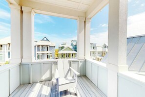 A covered balcony with a view of neighboring houses. - Sunshine Overtime | Water Views | Private Pool (Port Aransas)