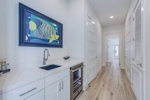 Cozinha moderna com pia, pintura emoldurada de peixe e dispensa.