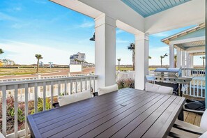 Eine Terrasse im Freien mit Tisch, Stühlen, einem Grill und Blick auf die umliegende Landschaft.