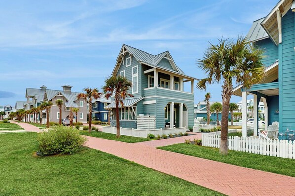A residential area with houses featuring gabled roofs and a paved walkway. - Casitas Sweetbay| Resort Amenities |Steps to Beach (Port Aransas)
