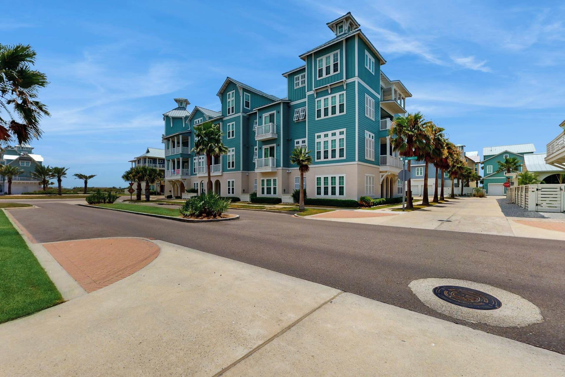 A multi-story residential building with a symmetrical facade, multiple balconies, and a well-maintained lawn.