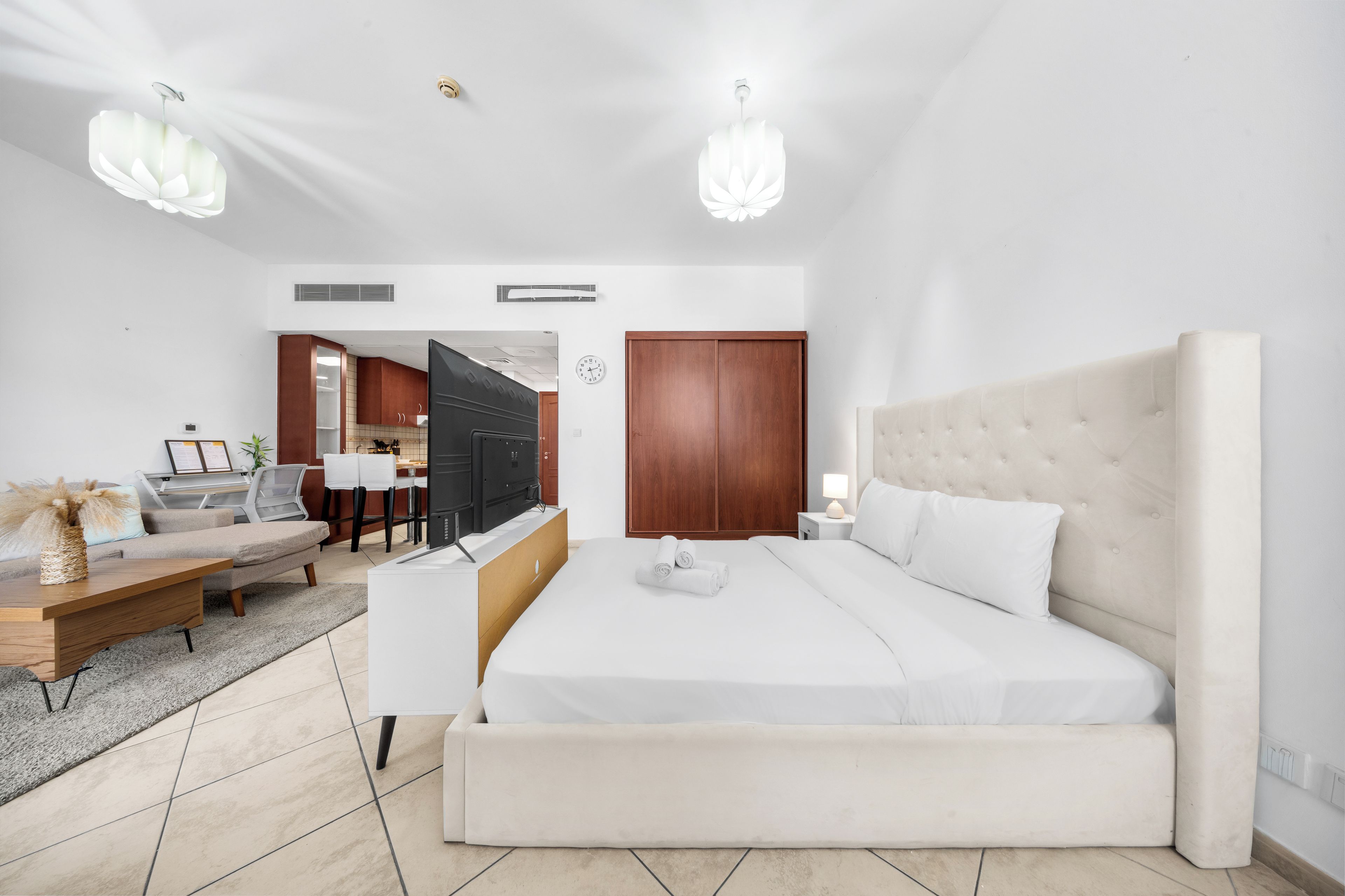 Una camera da letto moderna con un letto grande, comodini, una scrivania e una sedia.