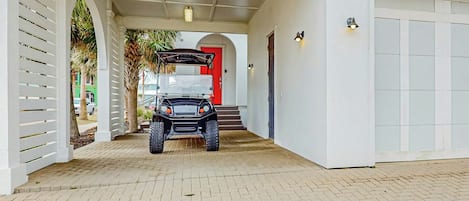 A covered driveway leading to a garage with a vehicle parked inside.