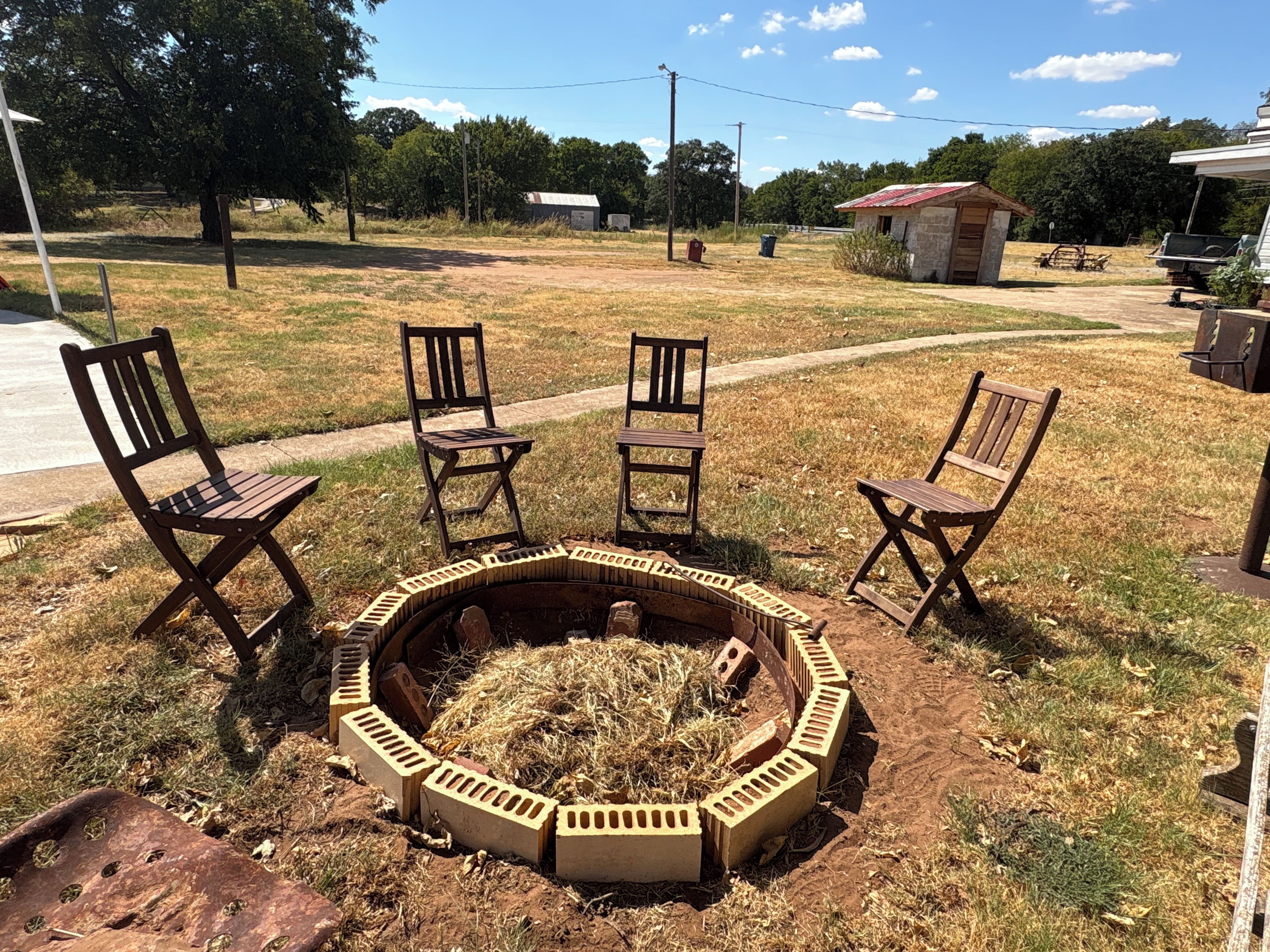 A fire pit with chairs arranged around it in an outdoor setting.