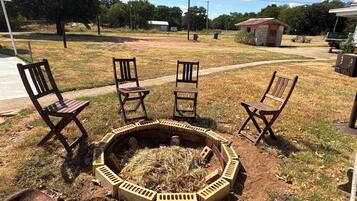 A fire pit with chairs arranged around it in an outdoor setting.