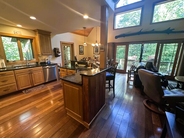 Una cocina amplia con armarios de madera, una isla central y un comedor con vistas al exterior.