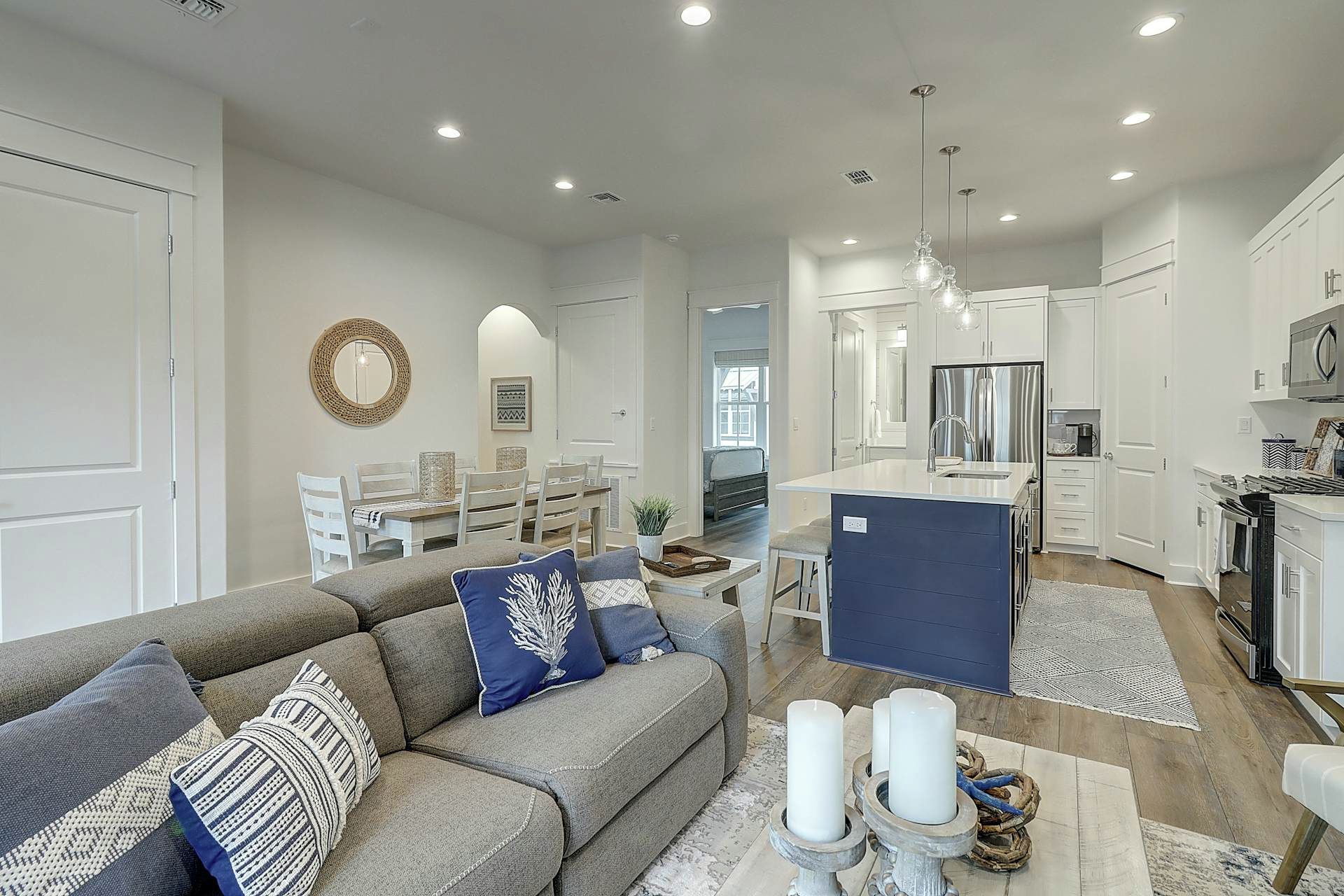 A modern living room with a sofa, dining area, and kitchen.
