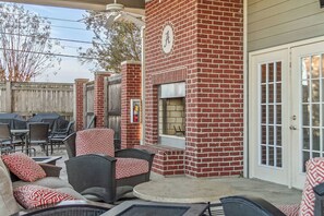 A patio area with outdoor furniture, a brick fireplace, and a covered seating area. - The Northstar Condo - Minnesota meets Bama (Tuscaloosa)