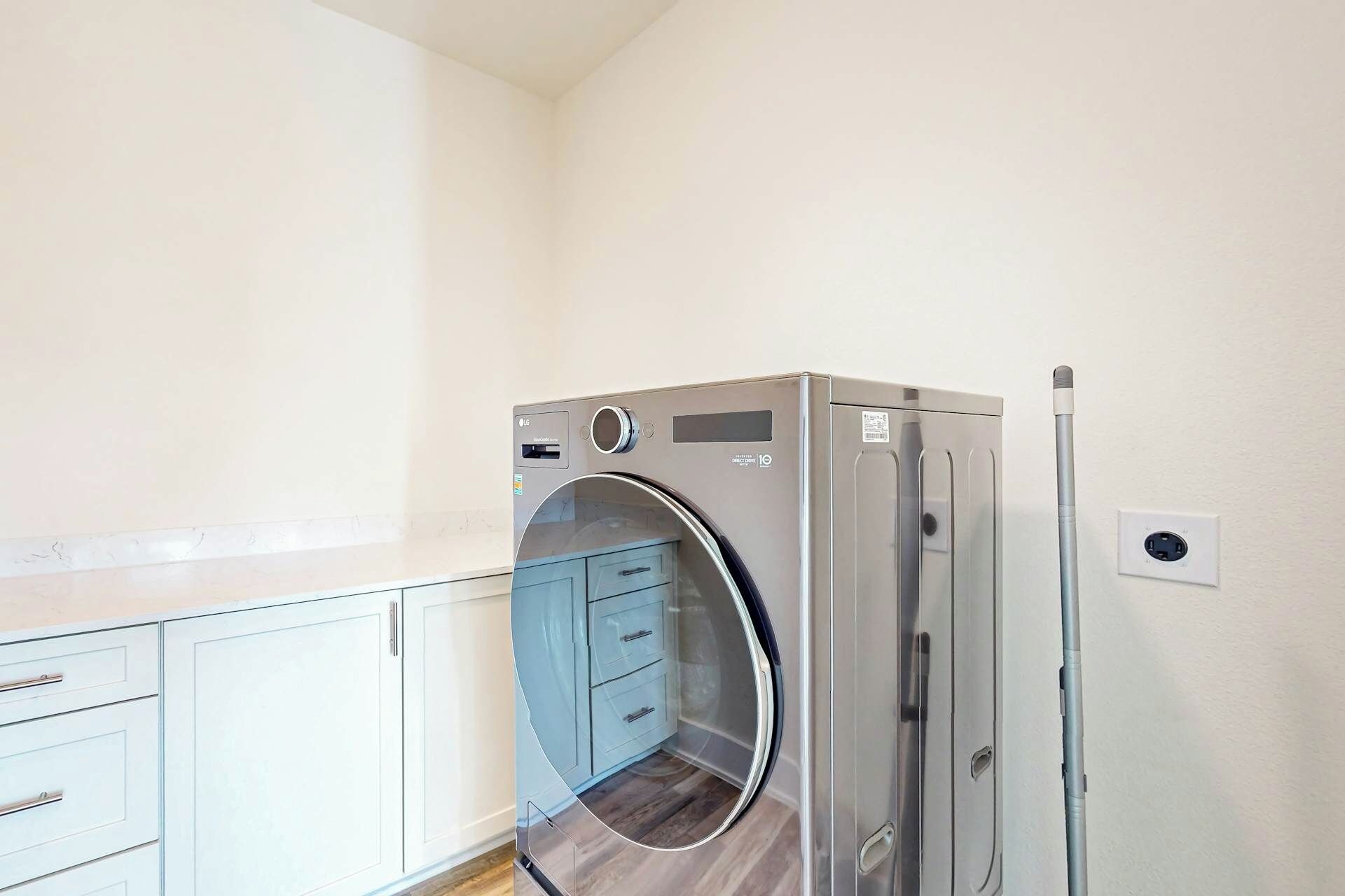 A compact, modern kitchen with a built-in LG refrigerator, a microwave, and a small oven.