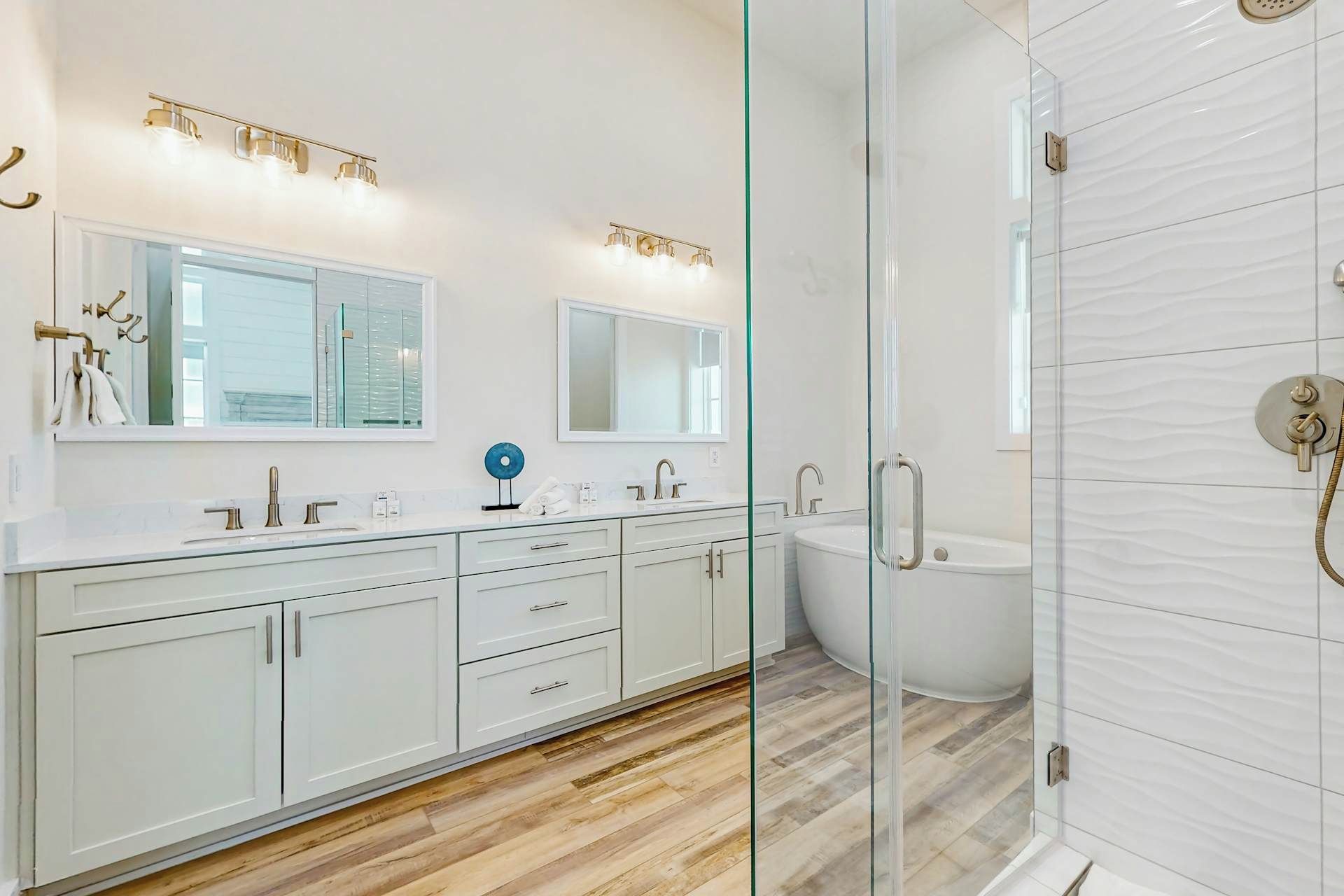 A modern bathroom with a glass shower enclosure, a white vanity with a double sink, and a toilet.