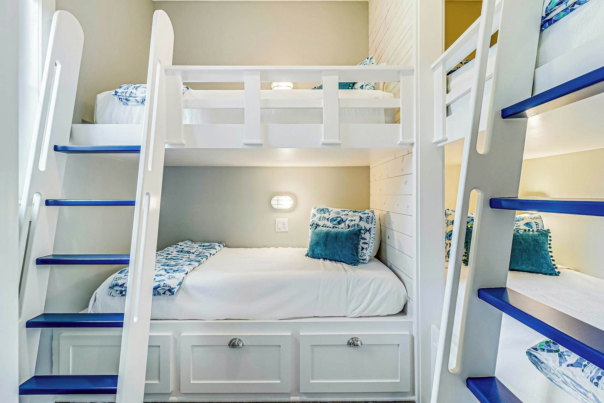 Habitación con literas, una cama inferior, una mesita de noche pequeña y un buró.