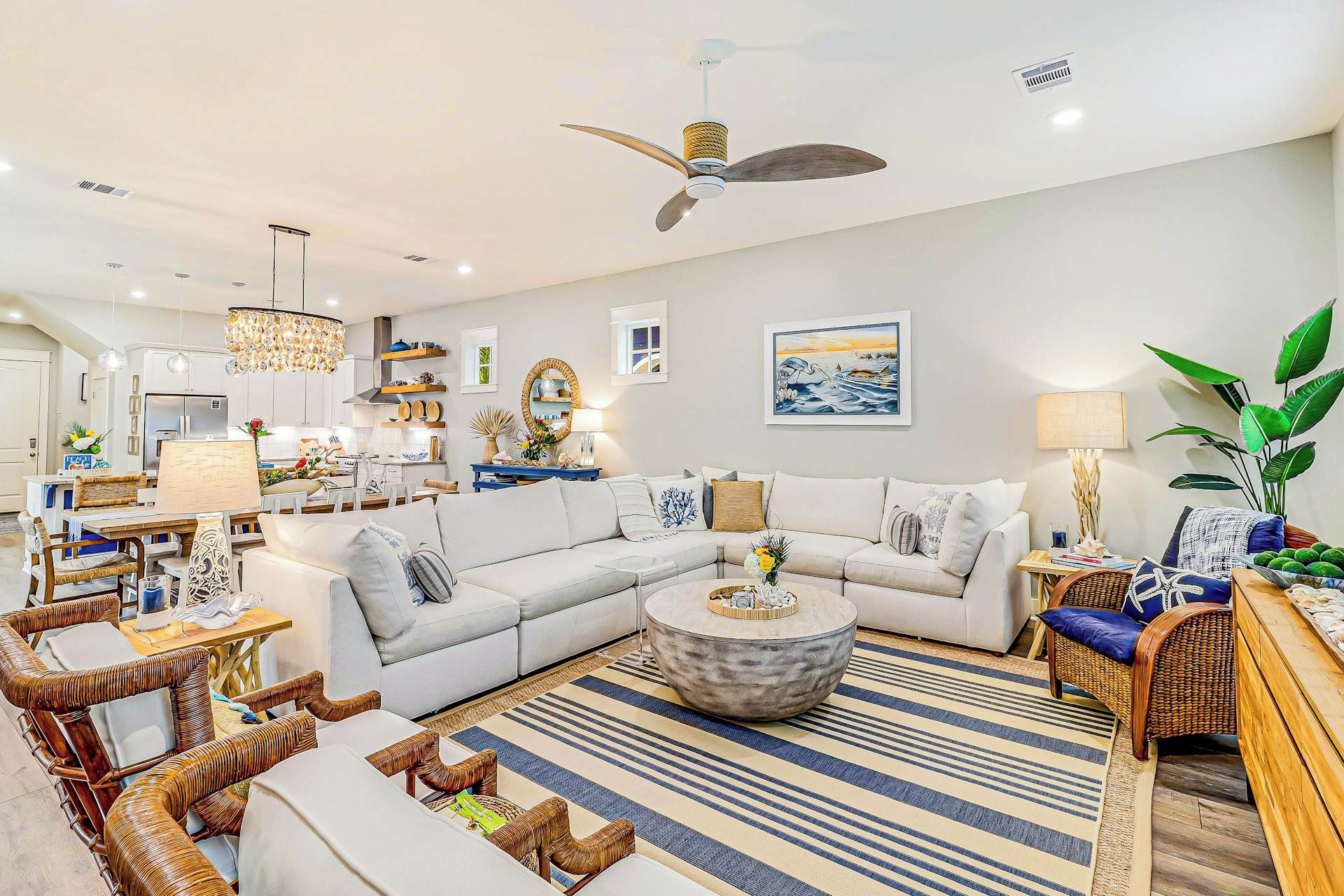A modern living room with a sectional sofa, a round coffee table, and a ceiling fan.