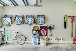 Eine Garage mit Fahrrädern, Angelruten und Aufbewahrungskörben.