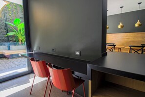 Ein modernes Interieur mit einem schwarzen Tresen, roten Stühlen und einer Holzwand.
