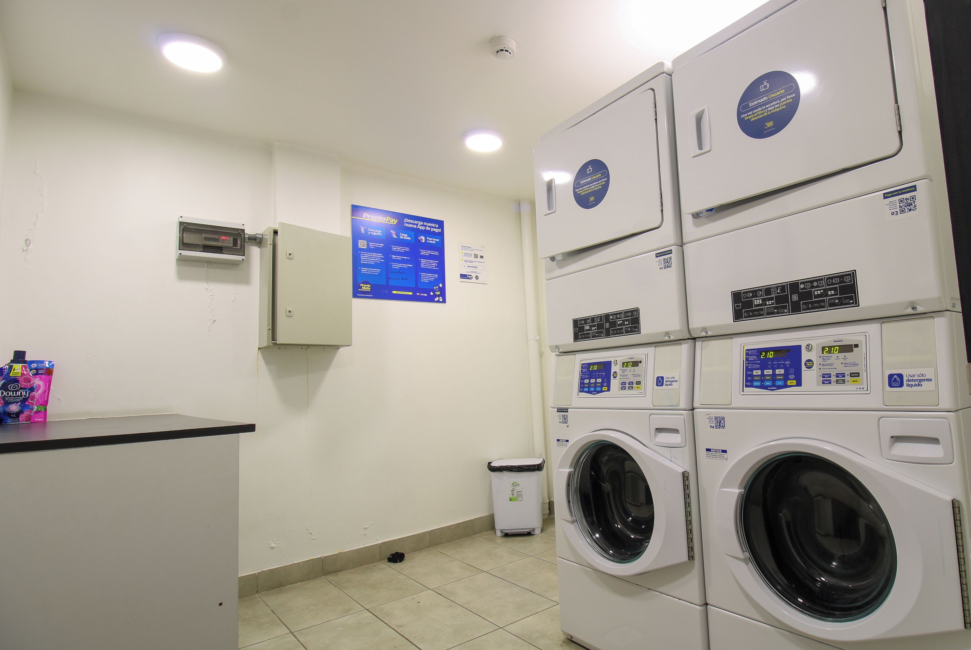 Bright, clean shared laundry room with multiple washers and dryers