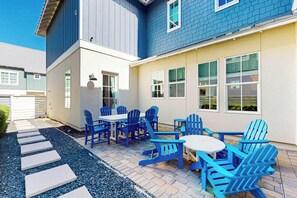 Eine Terrasse mit Sitzgelegenheiten im Freien und einem Weg zu einem Gebäude.