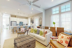 A spacious living area with a sofa, chairs, and a dining table. - Crab Manor | Steps to Beach | Resort Amenities (Port Aransas)