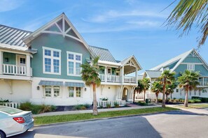 A residential building with a balcony, a car parked in front, and palm trees. - Crab Manor | Steps to Beach | Resort Amenities (Port Aransas)