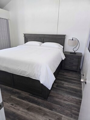 A single bed with a wooden headboard in a room with a wooden floor. - Walk to Ocean Beach & Sunset Cliffs, King Bed & AC (San Diego)