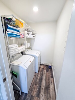 A laundry room with stacked towels, a washing machine, and a dryer. - Walk to Ocean Beach & Sunset Cliffs, King Bed & AC (San Diego)