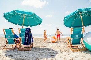 A beach scene with beach chairs and umbrellas at Palmilla Beach Resort & Golf Community. - Barefoot Bungalow | Golf Views | Steps to Beach (Port Aransas)