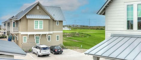 Ett bostadsområde med hus, en golfbana och parkerade bilar.