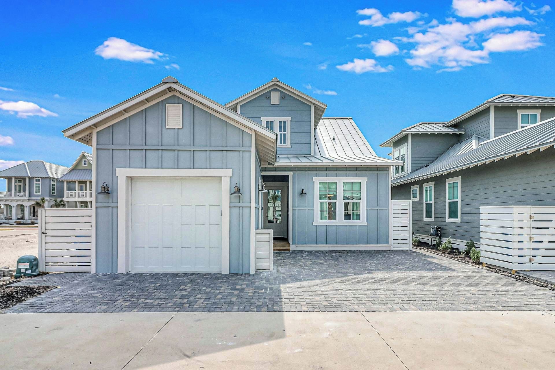 A residential property with a garage, a covered porch, and a paved driveway.