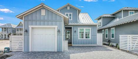A residential property with a garage, a covered porch, and a paved driveway.