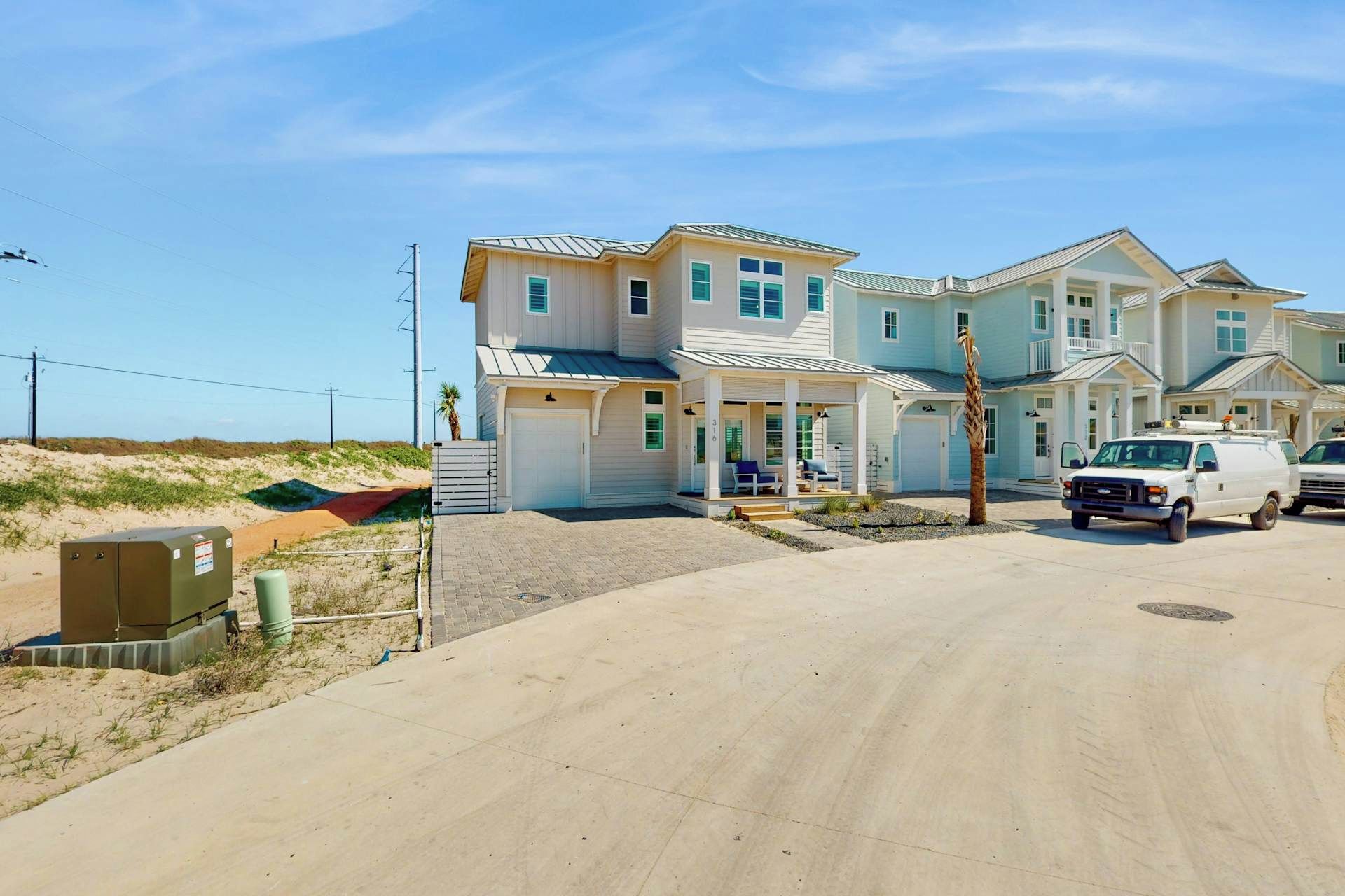 A multi-story residential building with a covered porch and a driveway.
