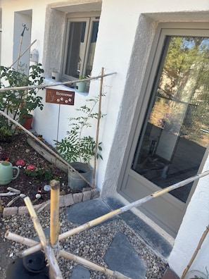 A garden area with a welcome sign, potted plants, and a small birdhouse. - Vrbo Property (Loches)