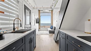 Une cuisine moderne dotée d’une grande fenêtre, d’un four encastré et offrant une vue sur la mer.
