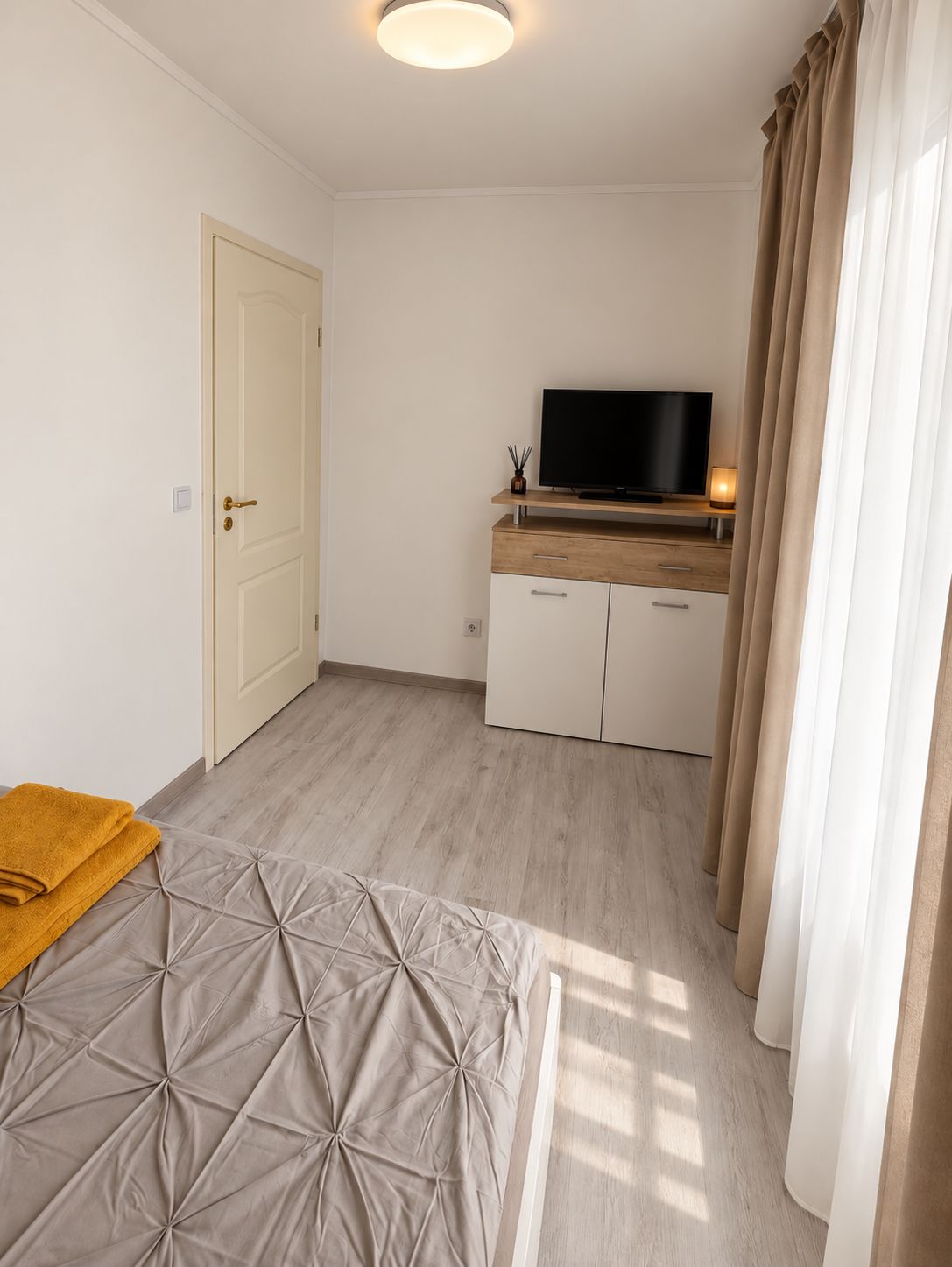 Une chambre à coucher avec un lit, une télévision et un bureau avec une chaise.